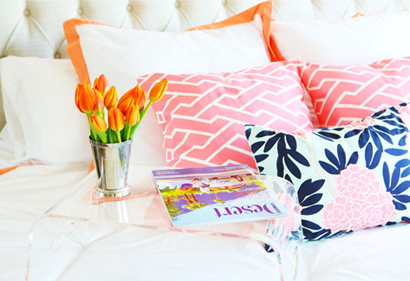 bed with pillows, flower, and magazine