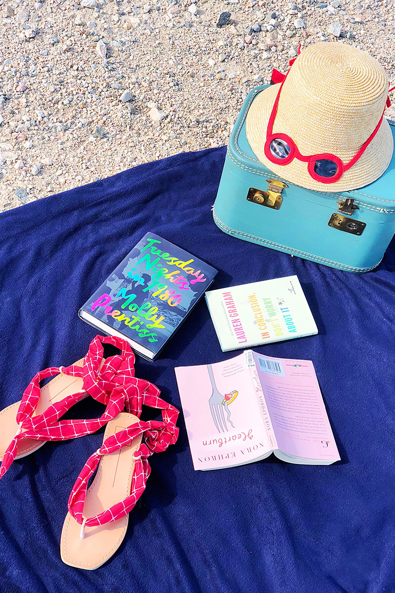 books, sandals, hat and bag on a blue mat