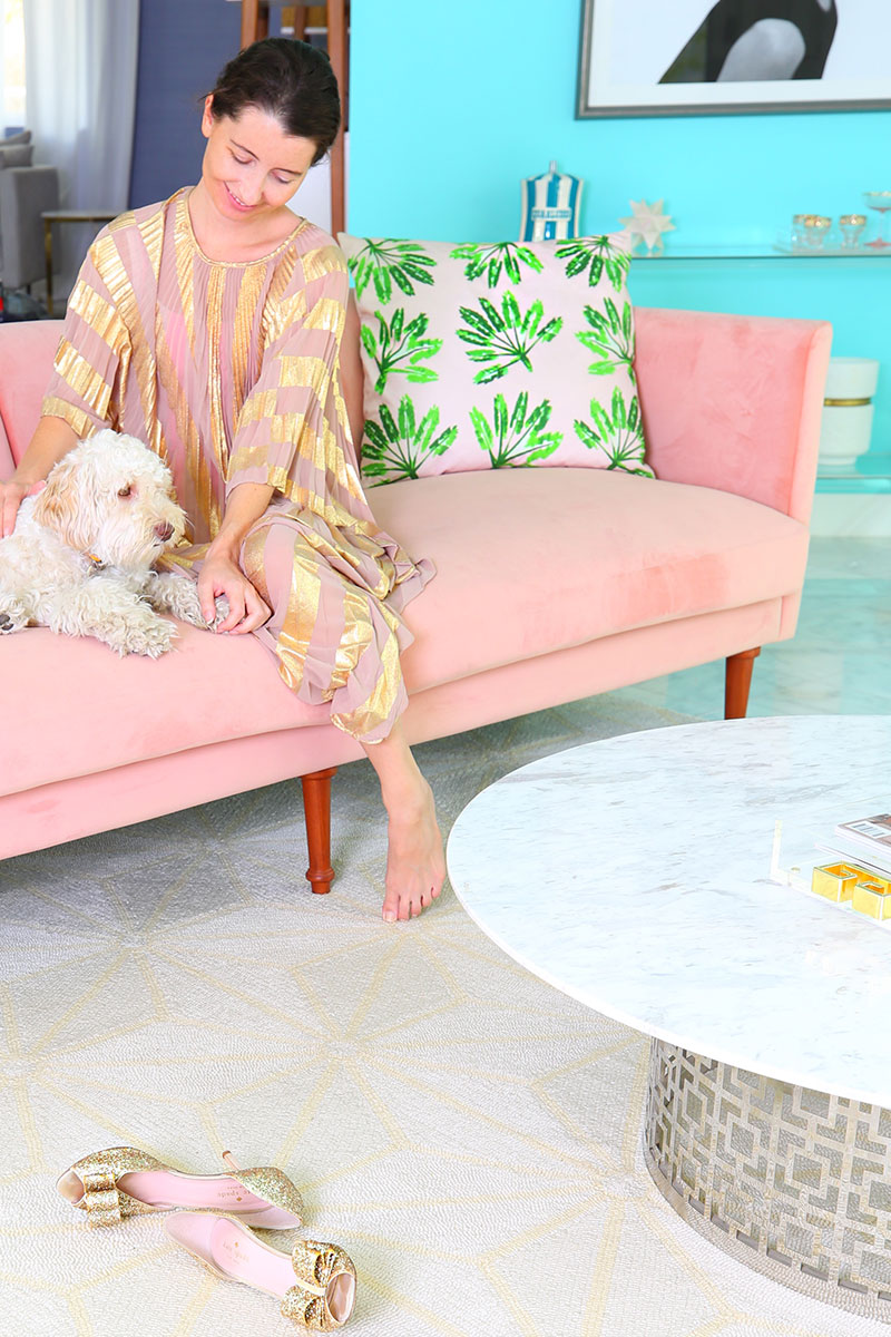 woman and dog sitting on pink couch