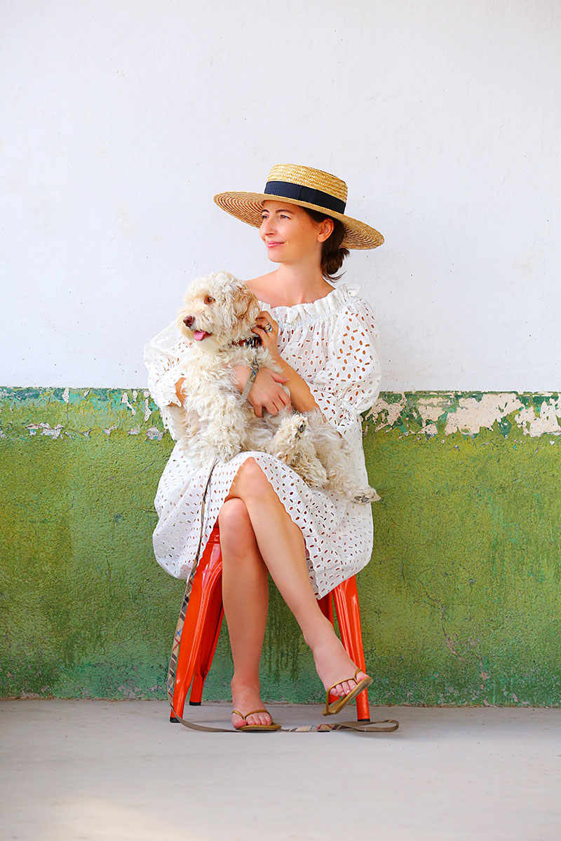 woman wearing white dress and sitting with her dog