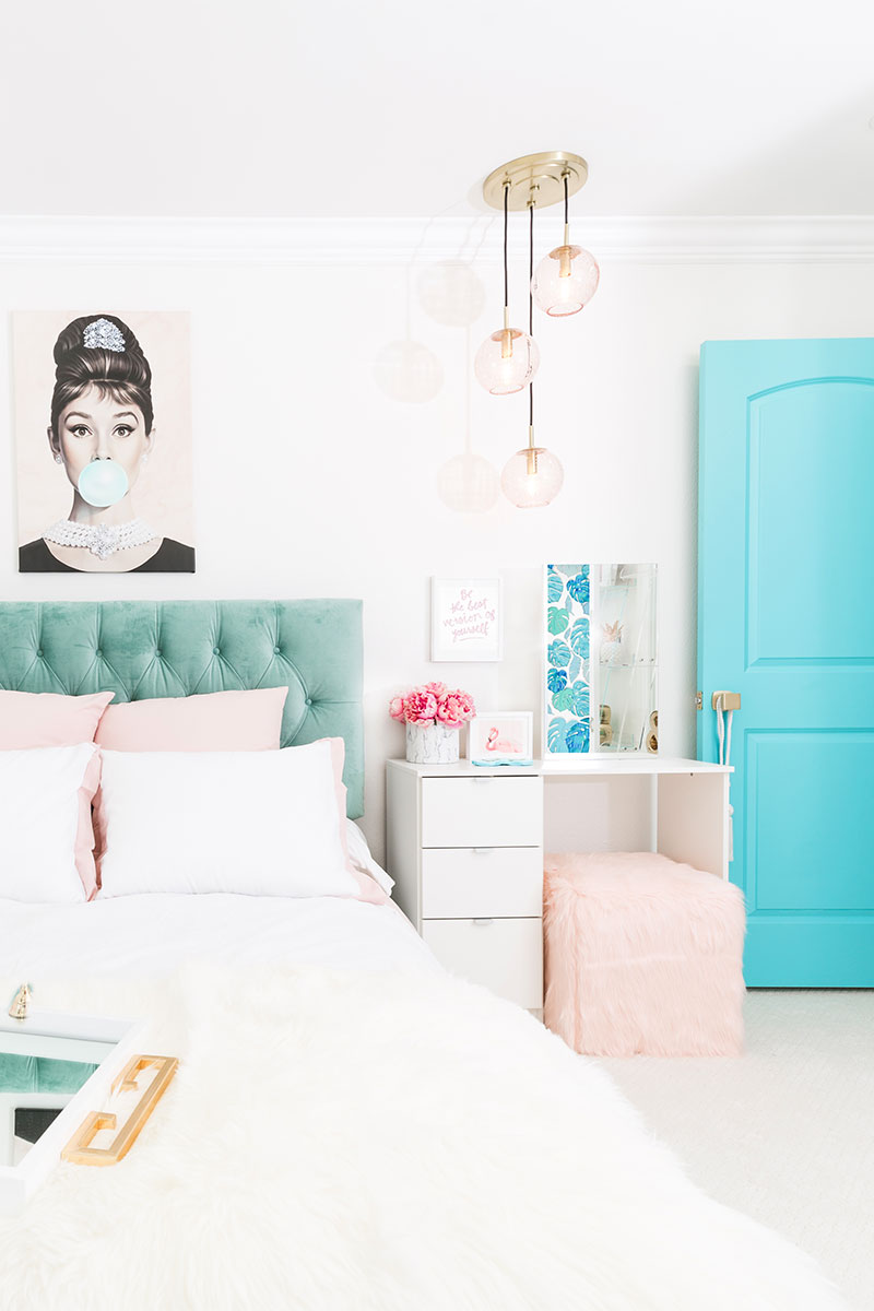 bedroom with bed, chandelier, vanity table, and aqua blue door