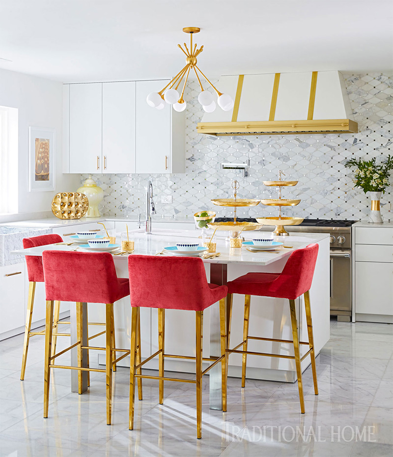 kitchen with white island, red high chairs, chandelier, and kitchen decorations 