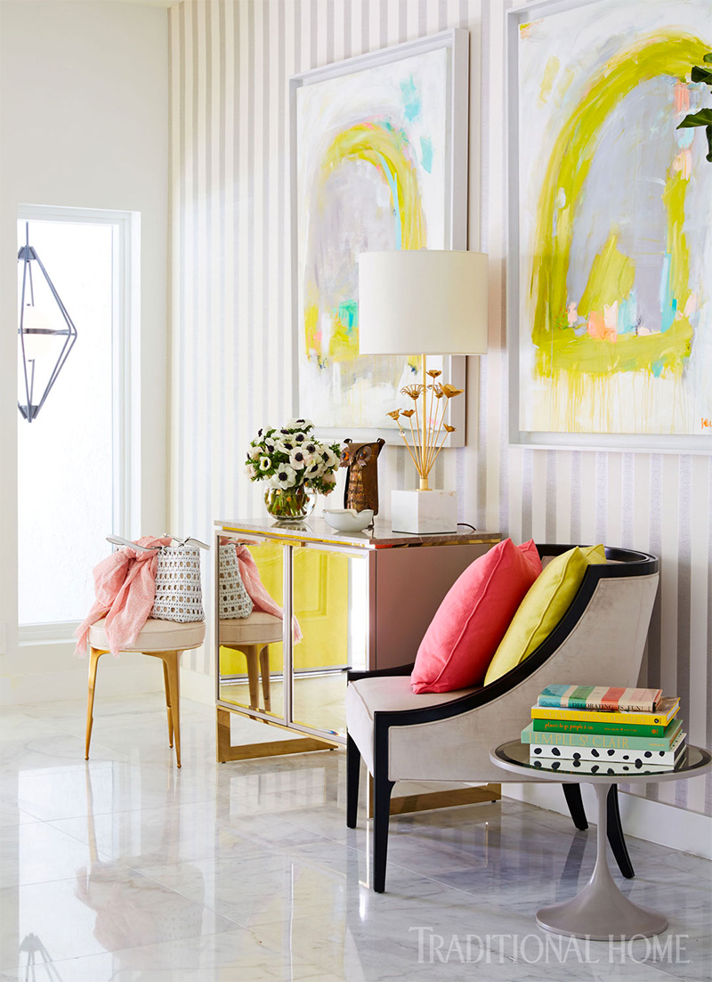 two chairs, two paintings, side table, with decorations traditional home magazine