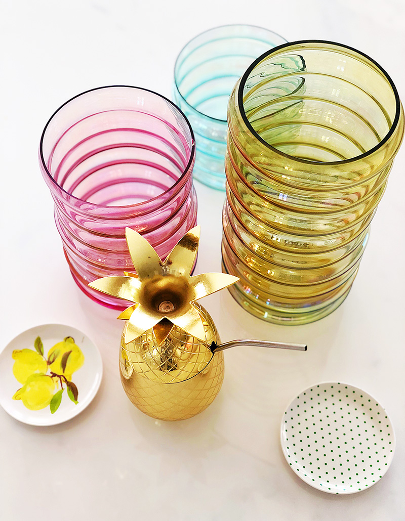 colorful jars, golden pineapple, and small saucers on top of white table