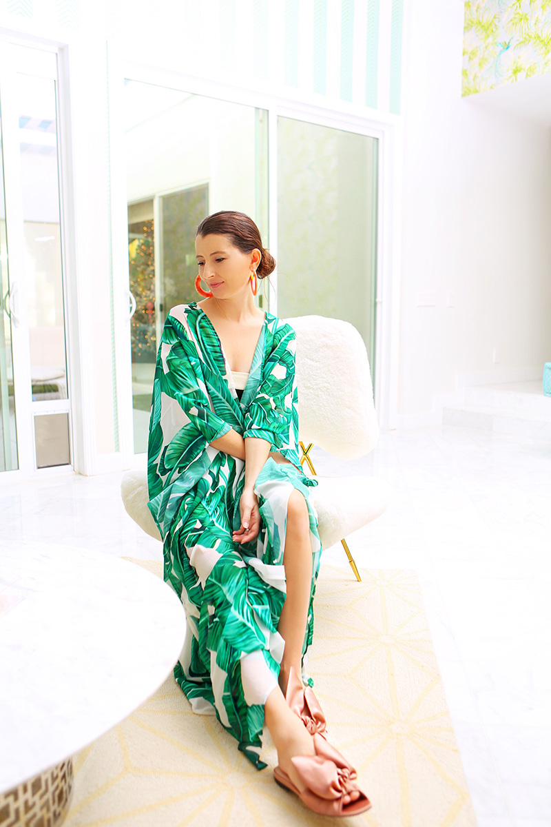 woman wearing a printed robe and sitting in a white Jonathan Adler Chairs