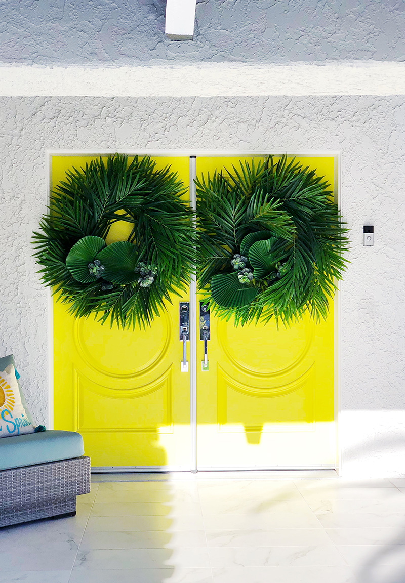 yellow door with with green leafy lanters as Christmas Decor in Palm Springs