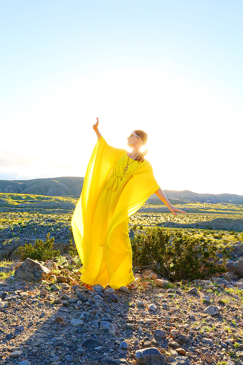 woman posing and wearing yellow caftan