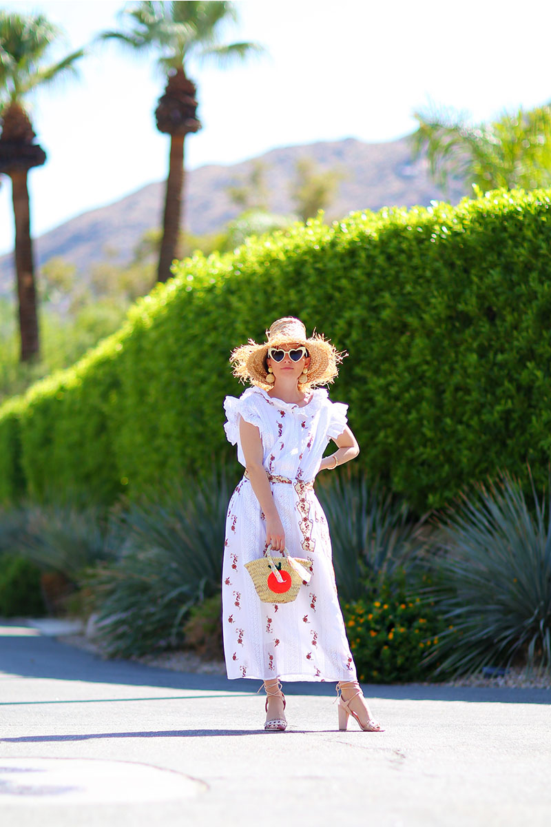 woman style white dress for fall with weaved hat, bag, and heart-shaped sunglasses 